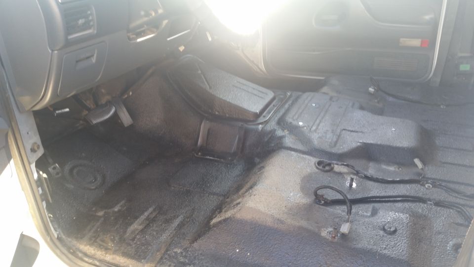 Vehicle interior floor with exposed wiring and a center console hump