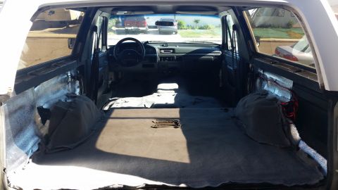 1992 Ford Bronco - The interior of an SUV is shown with the rear seats removed, revealing exposed insulation and wiring.