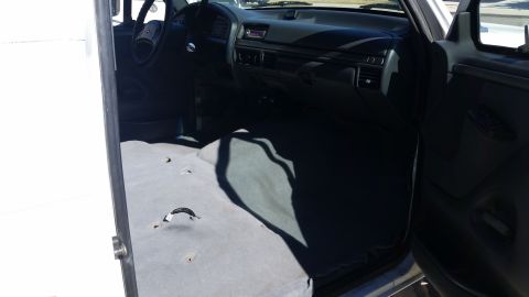 1992 Ford Bronco - The interior of a 1992 Ford Bronco shows a dark dashboard and gray carpeted floor.