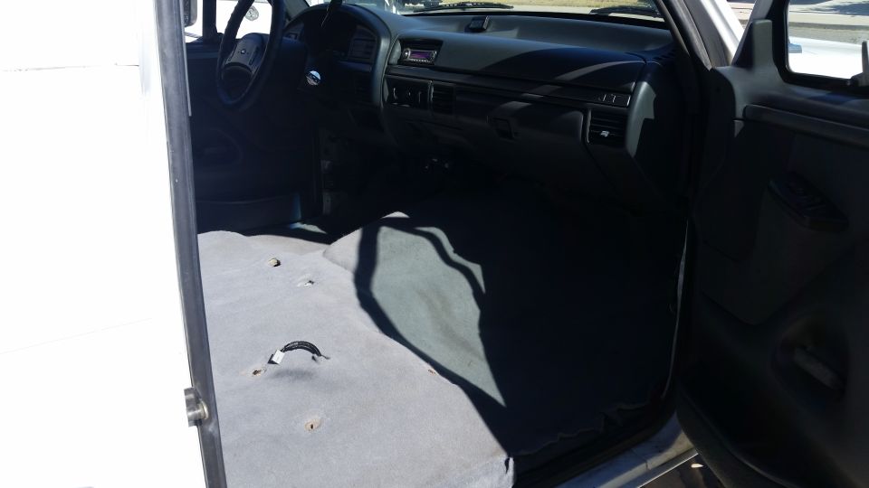 1992 Ford Bronco interior, gray carpet, dark dashboard, steering wheel, open door