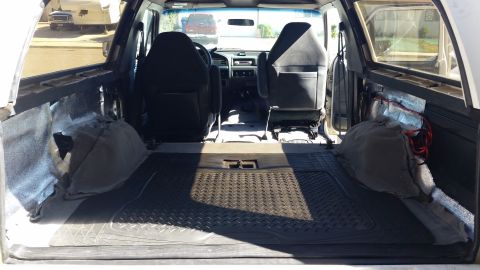 1992 Ford Bronco - The interior of a 1992 Ford Bronco, viewed from the rear cargo area towards the front seats and dashboard.