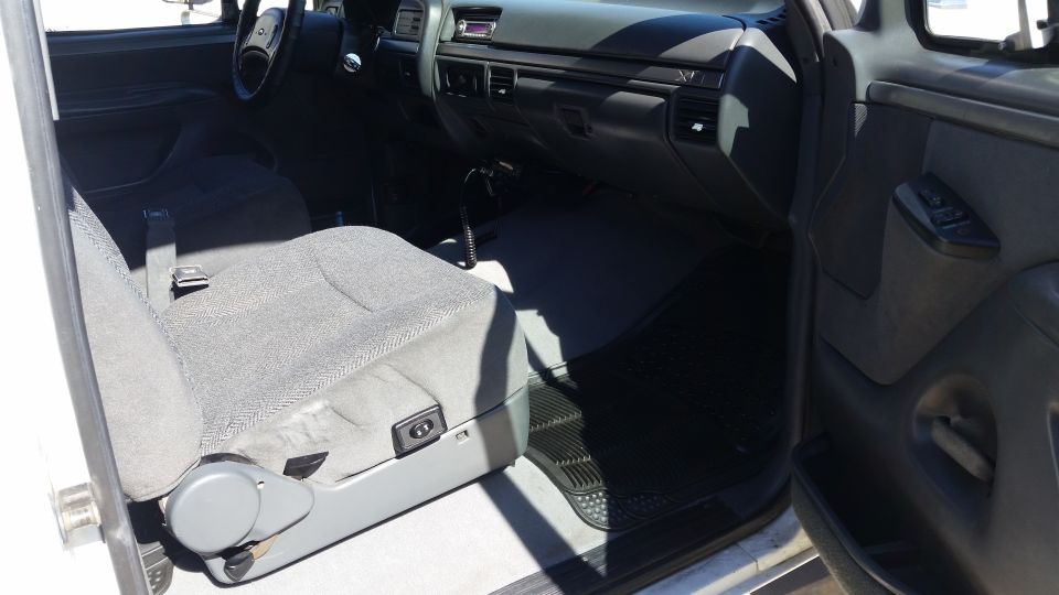 Interior shot of a truck showing the driver's seat, dashboard, and door panel