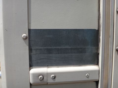 1995 Chevrolet P30 1 Ton - Step Van - Close-up of a step van's side door panel, showing its construction and color details.
