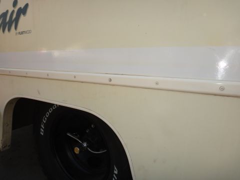 1995 Chevrolet P30 1 Ton - Step Van - Side view of a cream step van, showing a white stripe and a BFGoodrich tire. Text on the side reads "air by FLEETWOOD".