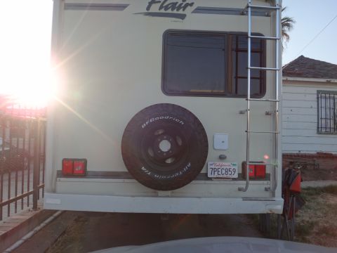 1995 Chevrolet P30 1 Ton - Step Van - The rear of an RV shows a spare tire mounted externally, a ladder, and a California license plate.