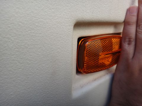 1995 Chevrolet P30 1 Ton - Step Van - Close-up of an orange side marker light, likely from a commercial vehicle's interior panel.