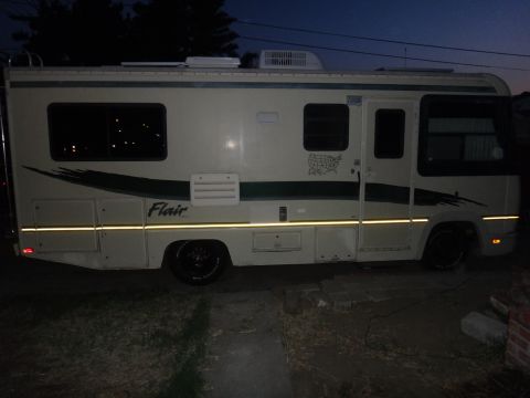 1995 Chevrolet P30 1 Ton - Step Van - Side view of a 1995 Chevrolet P30 1 Ton - Step Van motorhome, showing the 'Flair' decal and reflective tape.
