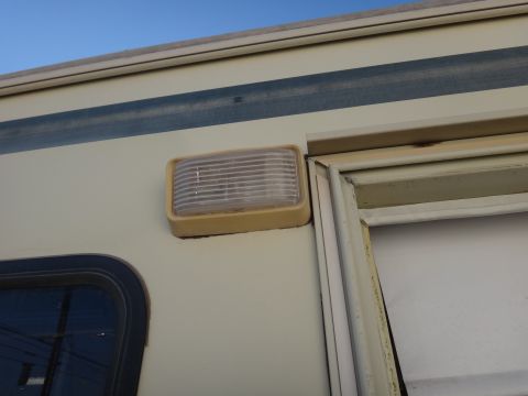 1995 Chevrolet P30 1 Ton - Step Van - Close-up of a side marker light on a cream-colored vehicle with a blue stripe.
