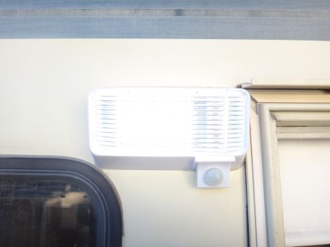1995 Chevrolet P30 1 Ton - Step Van - A close-up view of an exterior light fixture and motion sensor mounted on a vehicle's body.