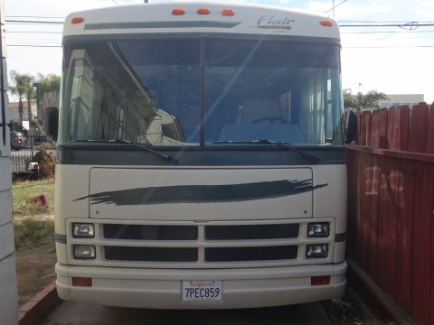 1995 Chevrolet P30 1 Ton - Step Van - The front of an RV shows its grille, headlights, and a distinctive brushstroke graphic on the front panel.
