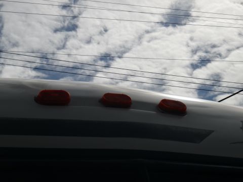 1995 Chevrolet P30 1 Ton - Step Van - The roof of a vehicle shows three red marker lights under a cloudy sky.