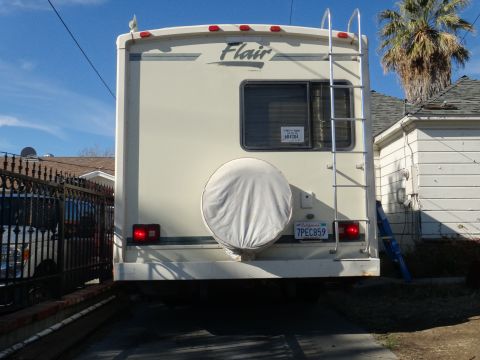 1995 Chevrolet P30 1 Ton - Step Van - The rear of an RV shows a spare tire cover, a ladder, and 'Flair' badging on the upper body.