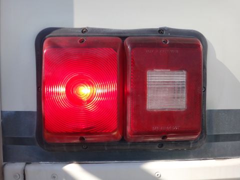 1995 Chevrolet P30 1 Ton - Step Van - Close-up of a vehicle's red taillight assembly, a circular brake light and a rectangular reverse light.