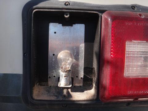 1995 Chevrolet P30 1 Ton - Step Van - The tail light assembly shows a bare bulb in its socket, with part of the red lens visible.