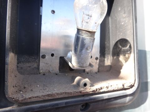 1995 Chevrolet P30 1 Ton - Step Van - Close-up of a dusty light bulb socket and mount, showing the interior of a vehicle component.