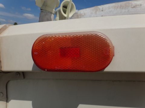 1995 Chevrolet P30 1 Ton - Step Van - Close-up of a red oval marker light with a textured lens and internal reflector.