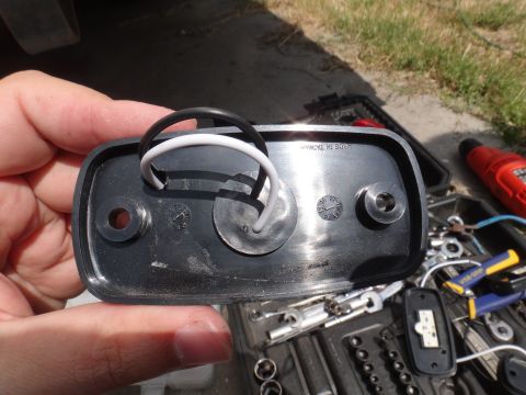 1995 Chevrolet P30 1 Ton - Step Van - A hand holds a vehicle light assembly with wires, with tools scattered nearby.