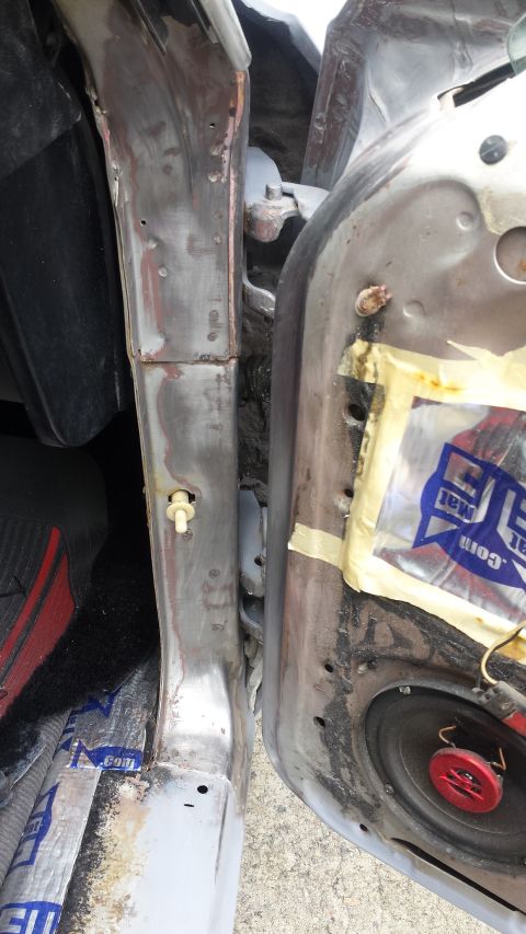 1976 Ford Ranchero - The interior door panel and jamb of a vehicle, revealing exposed metal and sound dampening material.