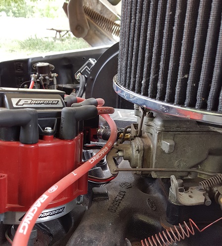 1978 Ford Bronco - Close-up of an engine bay a red Proform distributor cap and a chrome-ringed air filter.