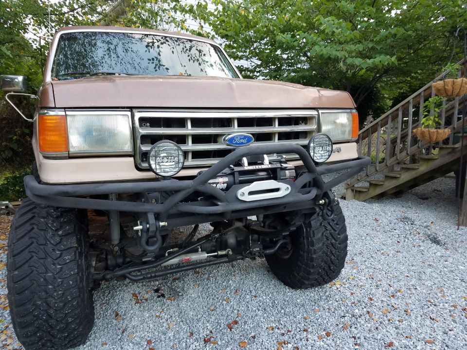 Tan Ford truck front view with custom bumper and winch
