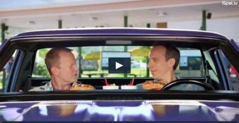 1971 Ford Ranchero - Two men eat hot dogs while sitting inside a purple pickup truck.