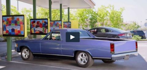 1971 Ford Ranchero - A blue 1971 Ford Ranchero pickup truck is seen at a drive-thru with menu screens in the background.