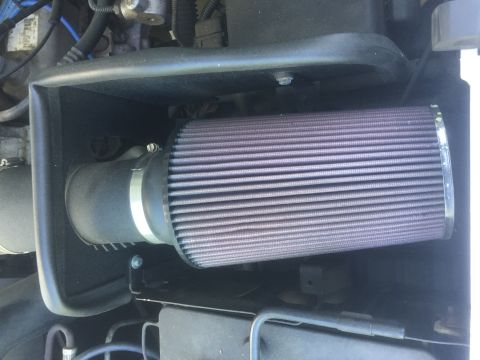1995 Ford Bronco - Close-up view of an aftermarket engine air filter installed in a vehicle's engine bay.