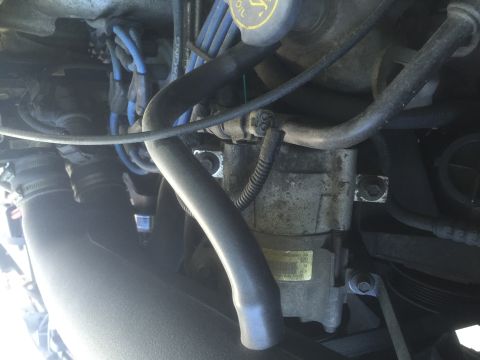 1995 Ford Bronco - Engine bay detail showing various parts and wiring harnesses connected to a central component.