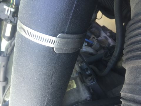 1995 Ford Bronco - A close-up view of an engine bay, focusing on an intake tube secured by a hose clamp.
