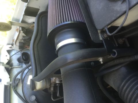 1995 Ford Bronco - Close-up of an engine's air intake system, showing the filter and associated piping.