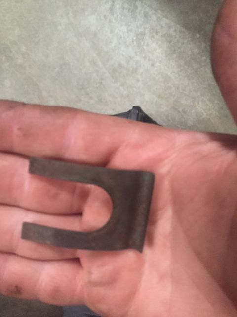 1995 Ford Bronco - A metal clip is held in a hand, showing its U-shaped opening and bent edges.