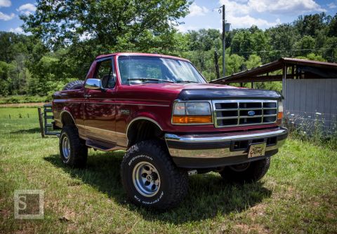 1995 Ford Bronco - This lifted Ford Bronco is ready for adventure, parked outdoors on a sunny day.
