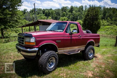 1995 Ford Bronco - This lifted 1995 Ford Bronco features a two-tone paint scheme and a spare tire mounted on the rear.