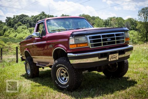 1995 Ford Bronco - This 1995 Ford Bronco is shown in a three-quarter front view, off-road tires and a classic Ford emblem on the grille.