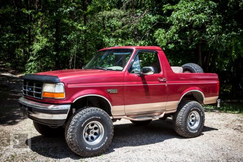 1995 Ford Bronco - This red 1995 Ford Bronco features tan two-tone trim and a spare tire mounted in the cargo area.