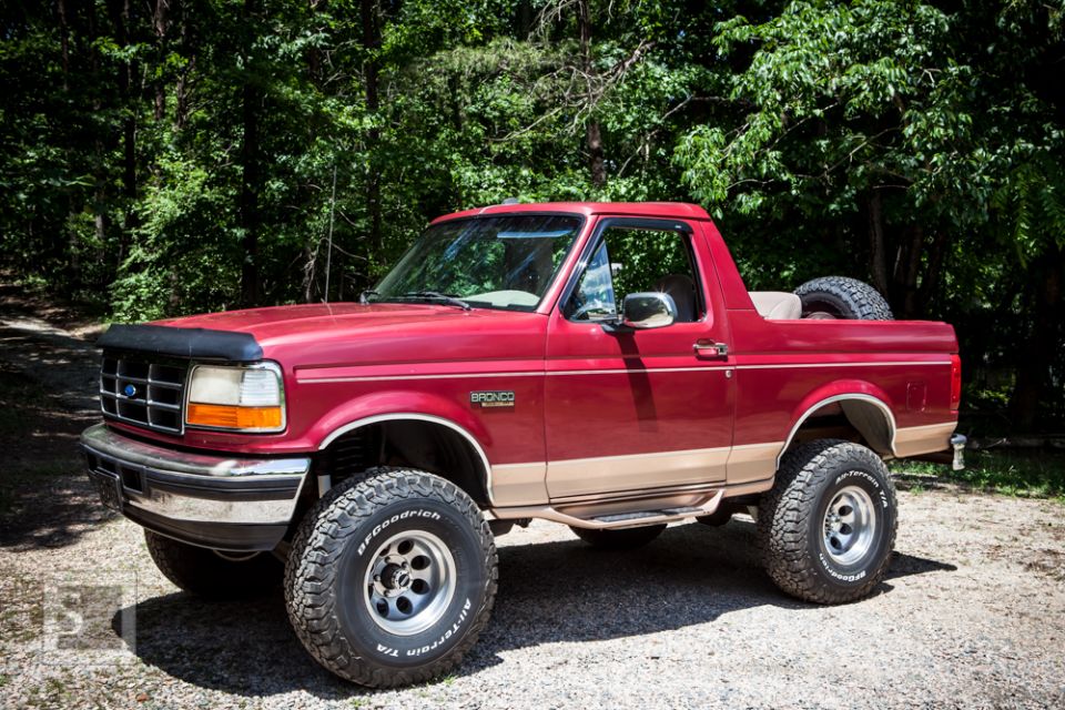 Red 1995 Ford Bronco 3/4 front view with tan trim and spare tire