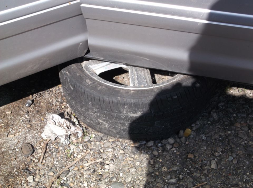 Flat tire under gray car door