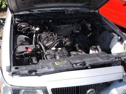 1999 Mercury Grand Marquis - Engine bay of a 1999 Mercury Grand Marquis, showing the V8 engine and associated components.