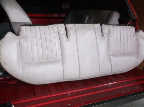 1999 Mercury Grand Marquis - Close-up of a light-colored perforated rear seat with vertical stitching, likely removed from a vehicle.