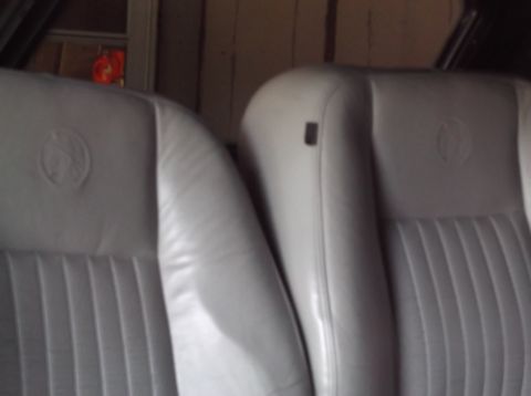 1999 Mercury Grand Marquis - Close-up view of gray leather interior seats, possibly from a sedan, showing embossed emblems on the headrests.