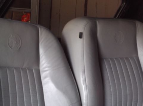 1999 Mercury Grand Marquis - Interior view of two light gray leather car seats with embossed emblems.