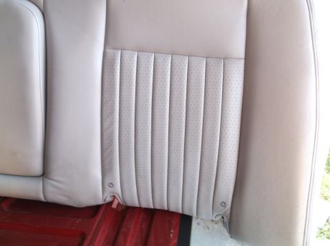 1999 Mercury Grand Marquis - Close-up view of a beige perforated and pleated car seat, likely from a sedan.