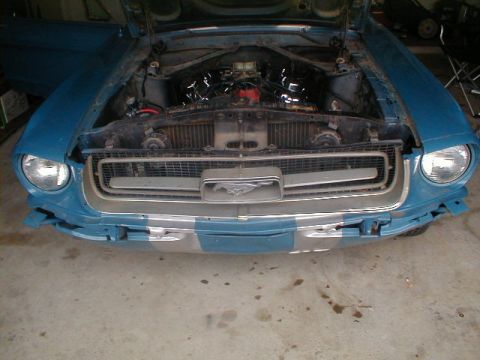 1967 Ford Mustang - The front of a blue 1967 Ford Mustang is shown with its hood open, revealing the engine bay.