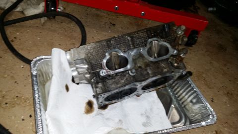 2007 Subaru Impreza - A disassembled engine cylinder head rests in a foil pan, awaiting repair or cleaning.