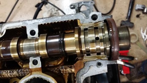 2007 Subaru Impreza - Close-up view of an engine's camshaft, showing internal components and oil residue.