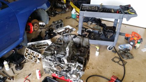 2007 Subaru Impreza - Engine components and a blue car fender are spread out on the floor, suggesting a repair or build process.