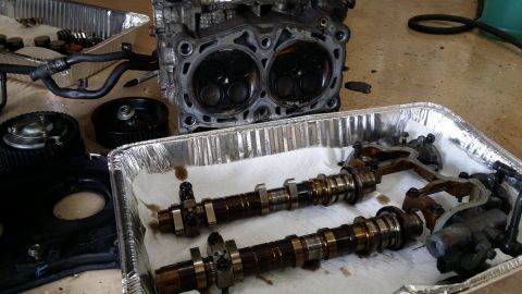 2007 Subaru Impreza - Disassembled engine components, including a cylinder head and camshafts, are laid out on a floor.