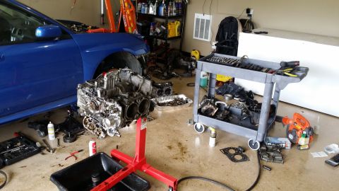 2007 Subaru Impreza - Engine removal in progress for a 2007 Subaru Impreza, with parts and tools laid out.
