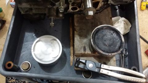 2007 Subaru Impreza - Engine parts laid out for inspection or repair, showing a clean piston and a heavily soiled one.
