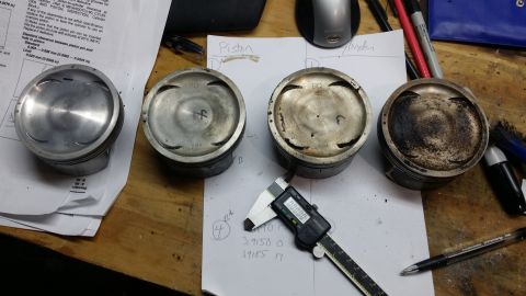 2007 Subaru Impreza - Engine pistons are shown with a digital caliper and technical documents, indicating a measurement or inspection process.